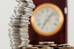Imagem de um relógio e moedas para artigo de hipoteca ou penhora de imóveis